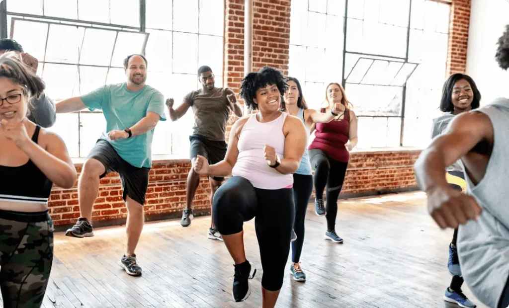 A group of people doing Zumba in a fitness class to stay fit.