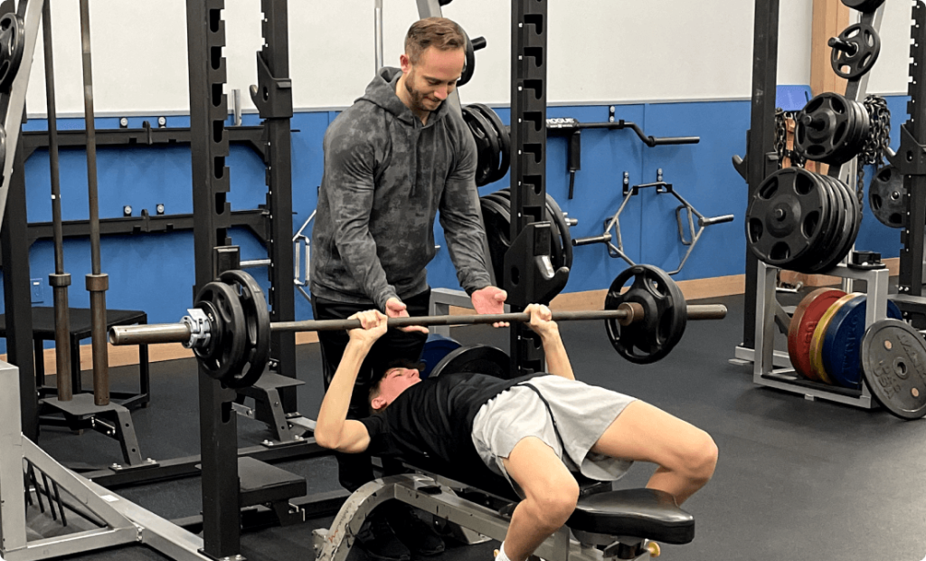 Young athlete training at vision sports club with a personal trainer
