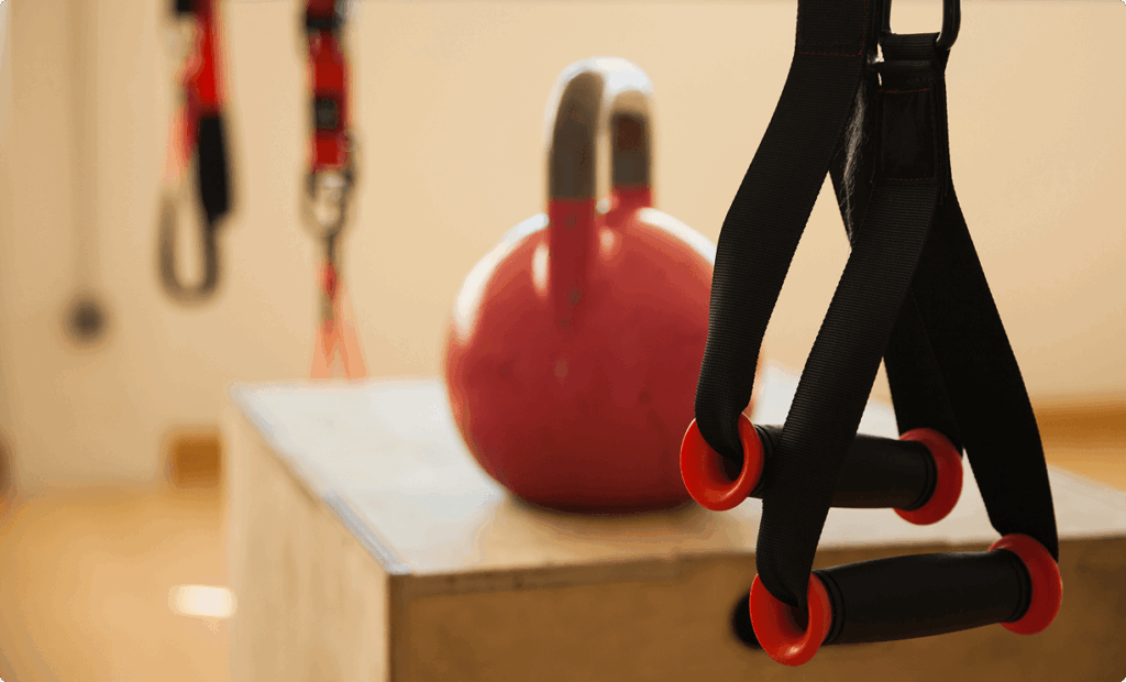 Kettlebell and TRX straps set up for a winter workout, illustrating strength and functional training at Vision Elite Training.