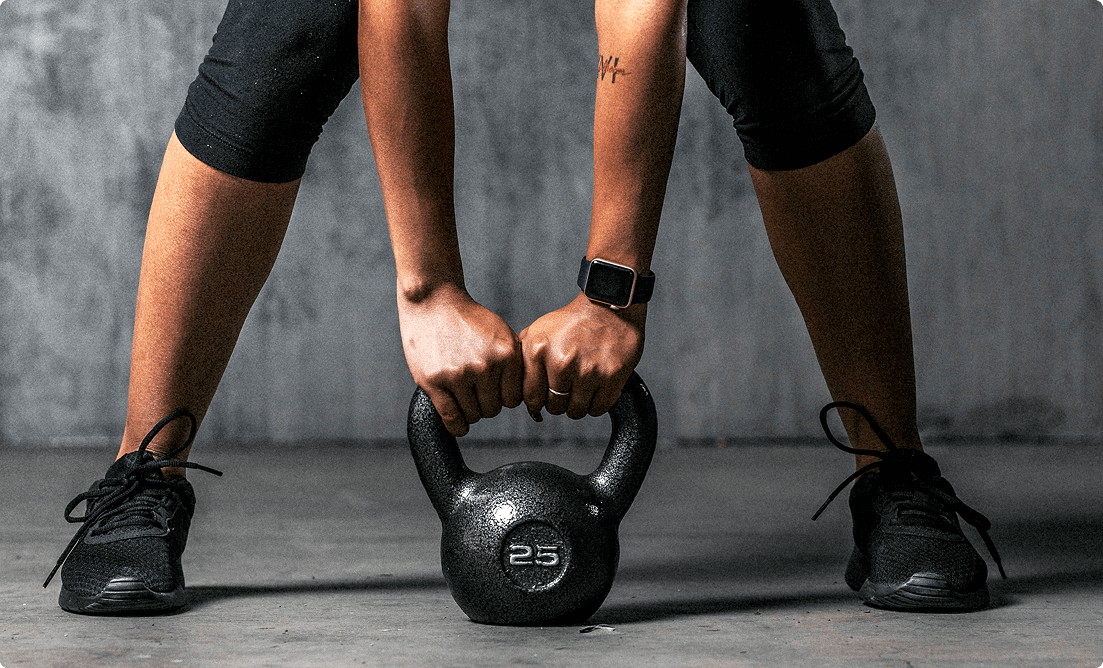 Man holding a kettlebell, performing a strength exercise to build full-body power at Vision Elite Training.