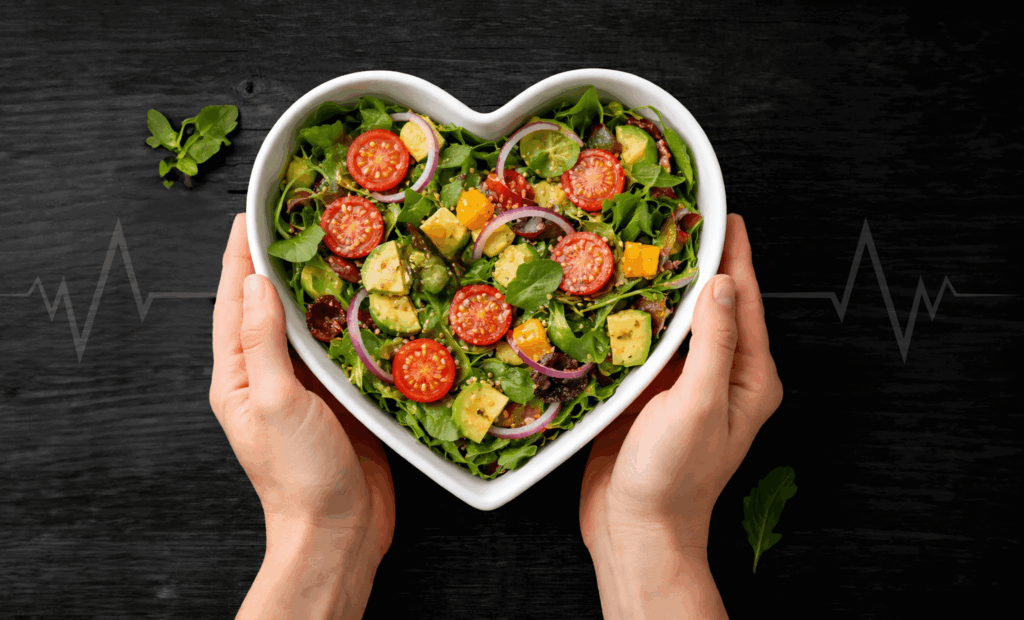 Heart-shaped bowl of fresh salad symbolizing nutrition and cardiovascular health at Vision Elite Training.